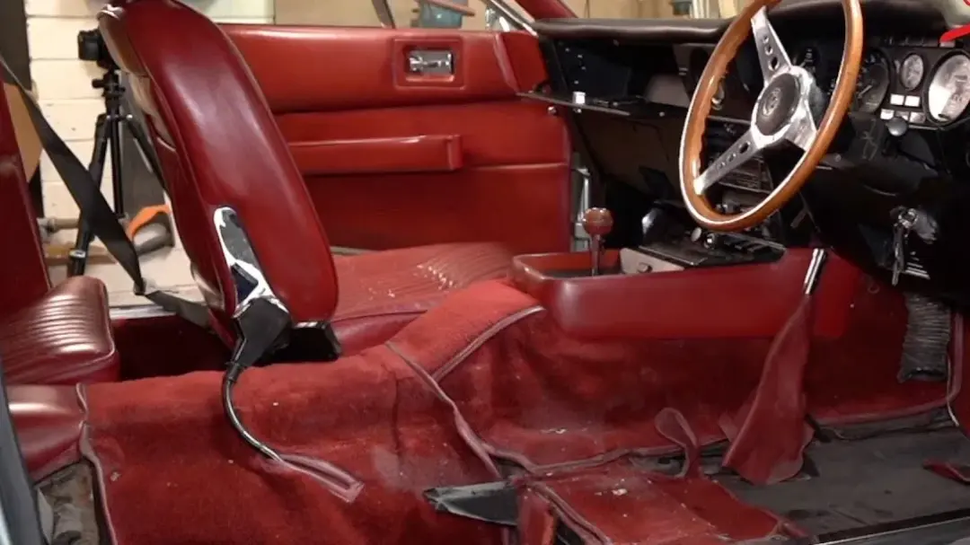 Red leather interior of a 1978 Aston Martin V8 in the workshop